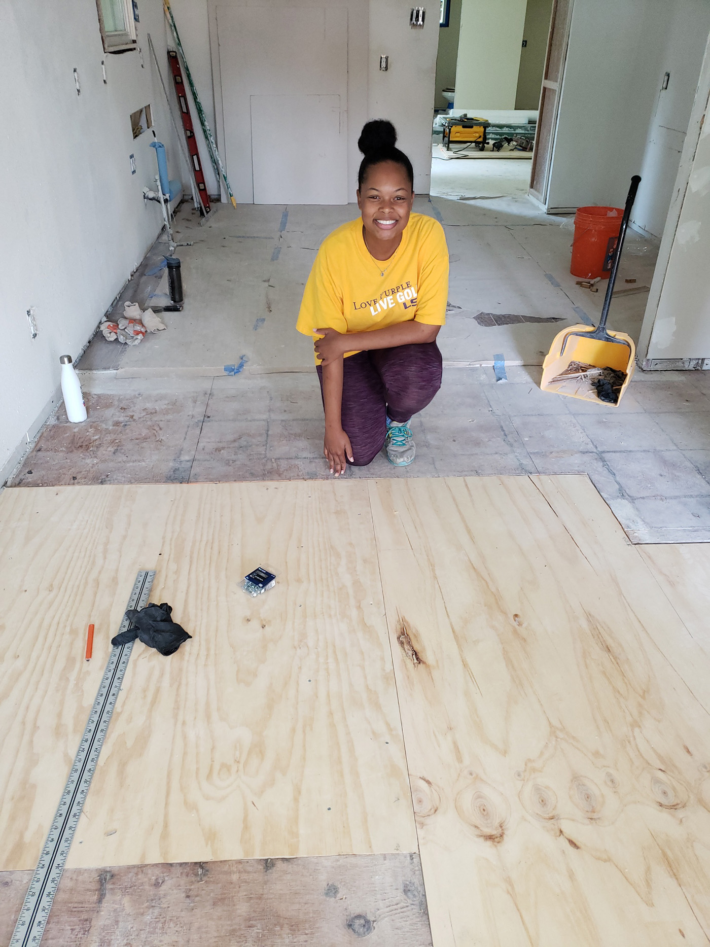 Kennedy and friend volunteer by painting at unfinished communityhome.