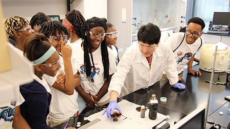 Students in lab with engineer