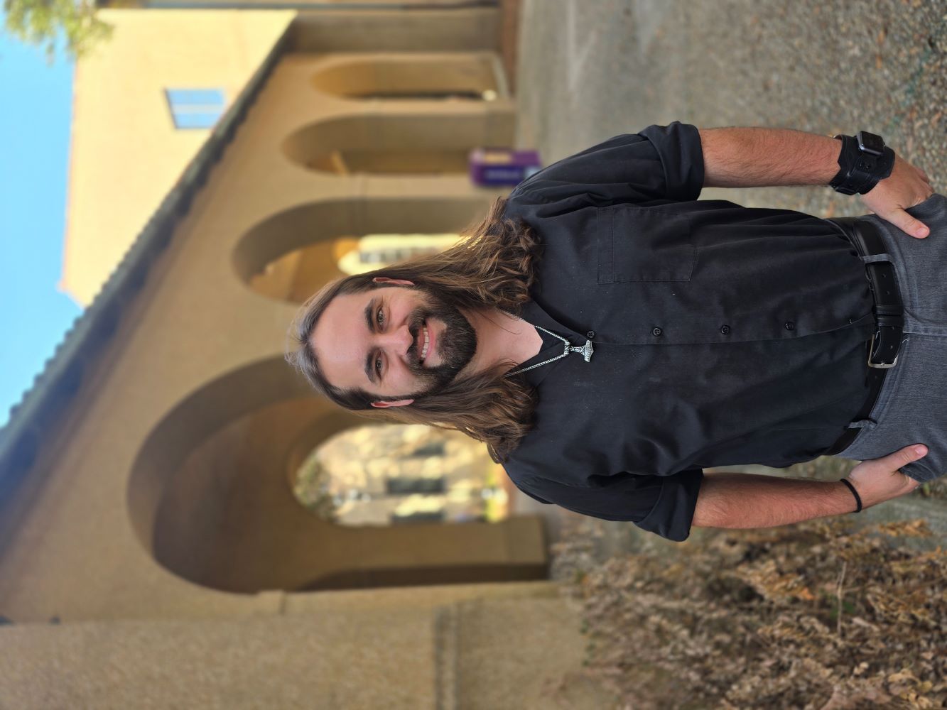 man standing in front of quad arches with black shirt