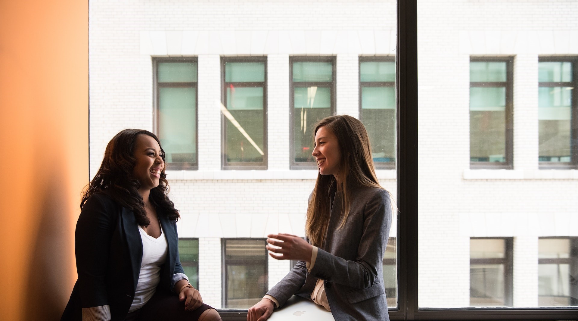 two people talk in front of a window