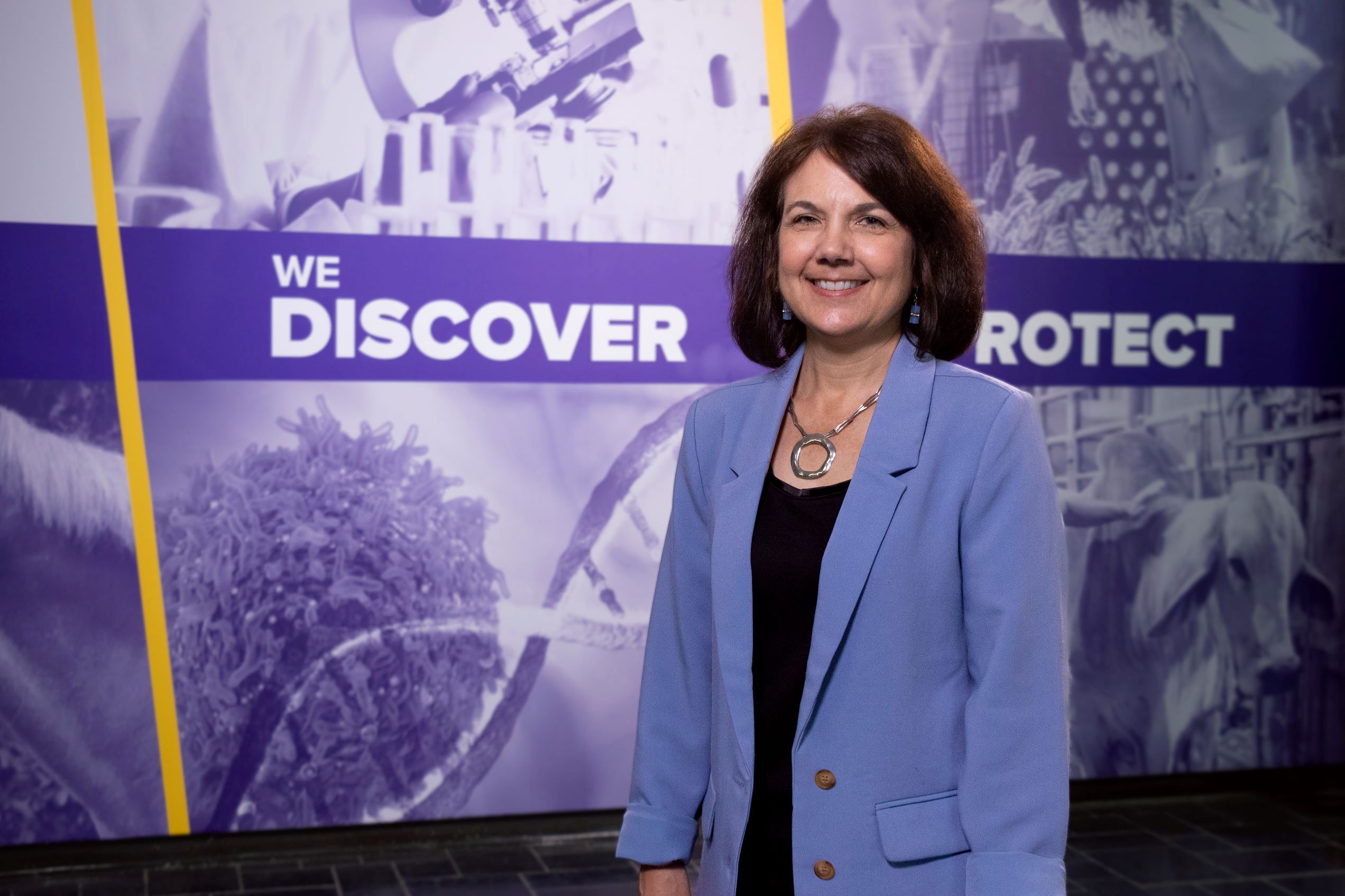 Tammy Dugas in front of LSU Disclosure sign