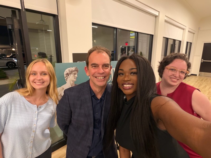 Michael DiResto, the Director of the Reilly Center, with three interns.