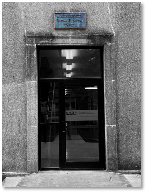 gray stone entry way with signage showing "Grover E. Murray" on the wing of the West building. 